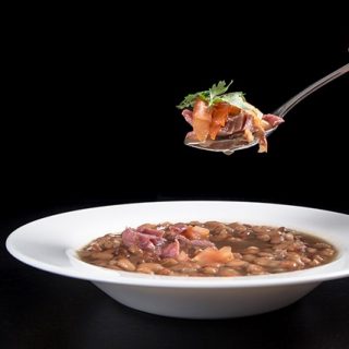 Pressure Cooker (Instant Pot) Smoky Ham Hock and Pinto Bean Soup in a white bowl
