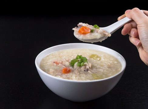 Pressure Cooker (Instant Pot) Turkey Rice Porridge in a white bowl with a spoonful of soup above it