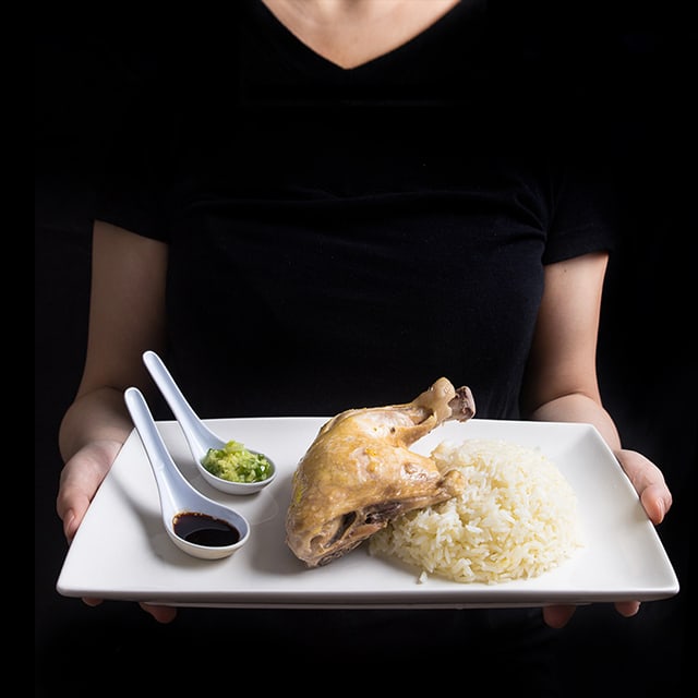 someone holding a tray with ingredients to make Hainanese Chicken Rice in Pressure Cooker Recipe