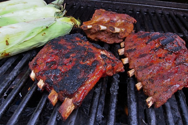 BBQ Baby Back Ribs in the pressure cooker being finished on the grill with corn on the cob