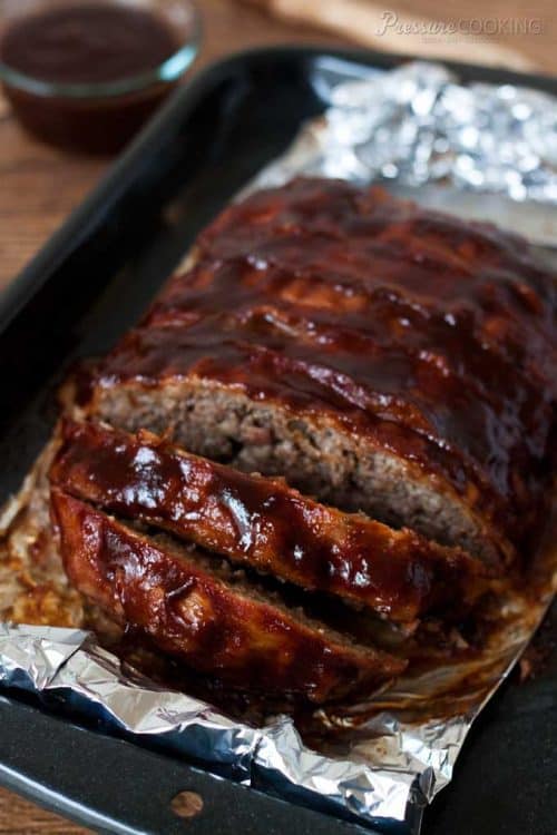 Instant Pot meatloaf covered in bacon and coated with bbq sauce sliced and ready to serve.