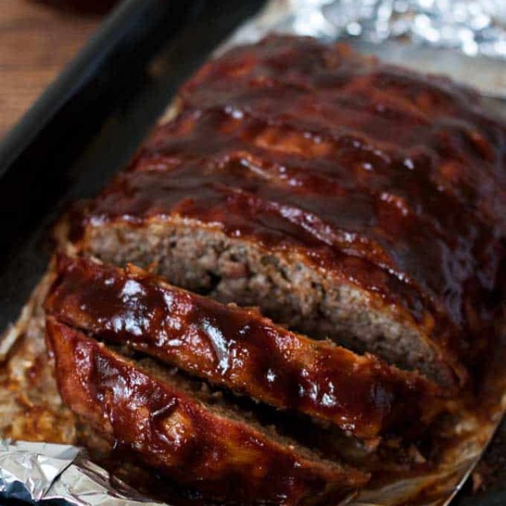 Instant Pot meatloaf covered in bacon and coated with bbq sauce sliced and ready to serve.