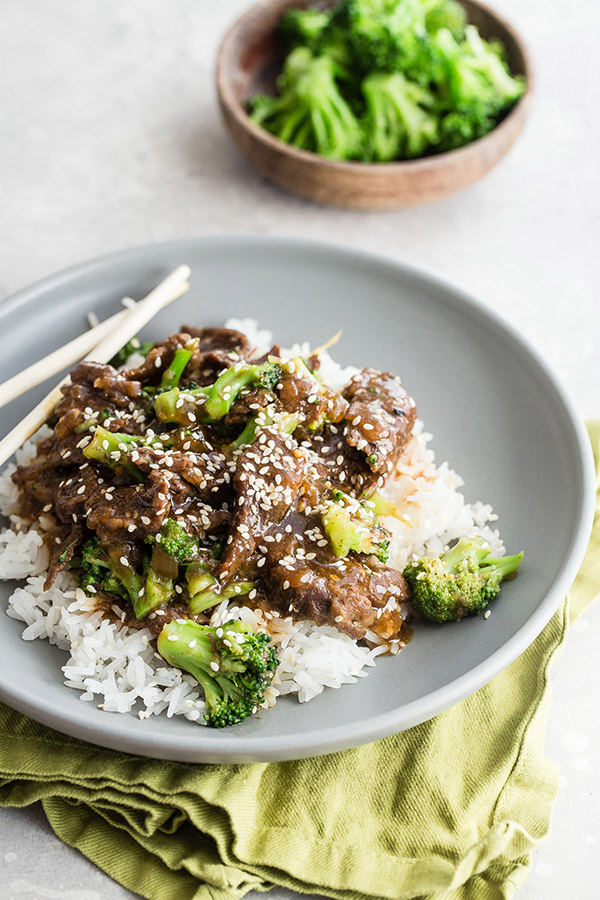 A plate of food with rice and broccoli over rice.