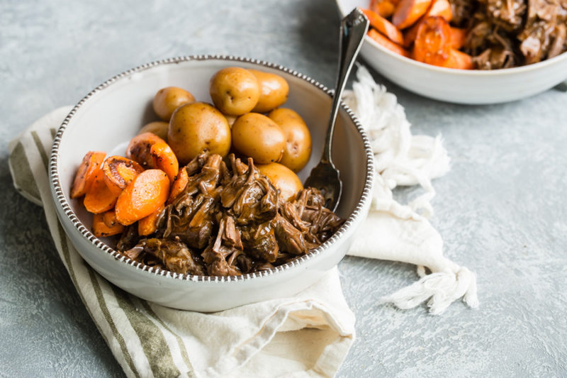 Pot Roast. potatoes and carrots served in a white bowl with fork