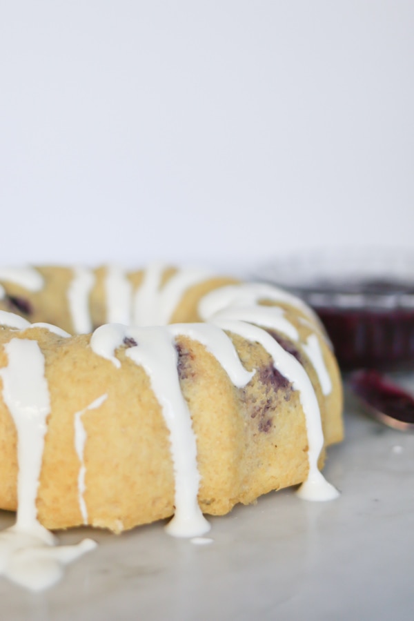 Close up photo of Pressure Cooker Berries and Cream Breakfast Cake drizzled with sweet icing