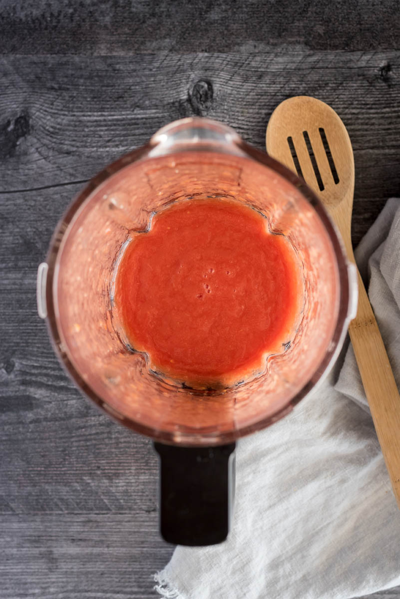 Overhead shot of the whole canned tomatoes blended inside of a blender jar.