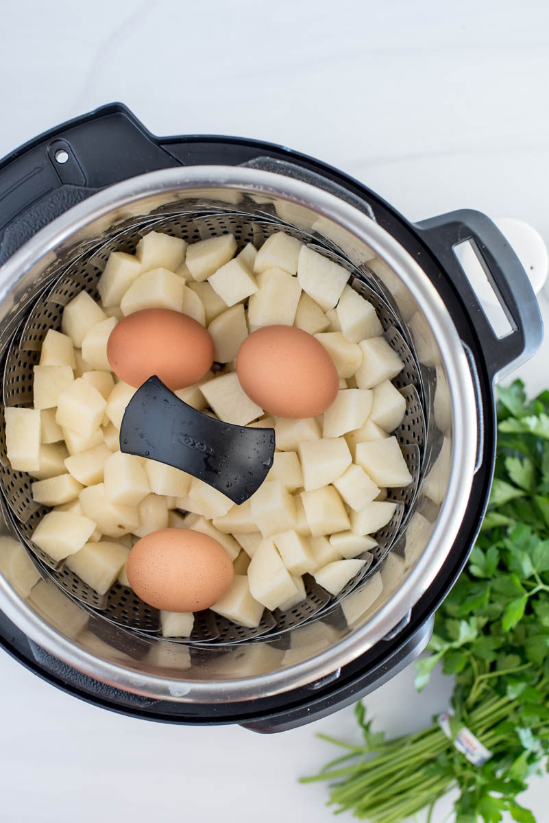 Overhead picture of diced potatoes and whole eggs placed in an Instant Pot to make BLT potato salad.