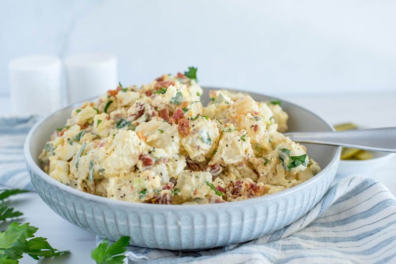 Close up picture of Instant Pot BLT potato salad with fresh parsley in the corner.