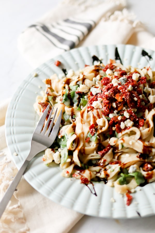 Cauliflower Fettuccine Alfredo on a white dinner plate with a fork sitting on the edge of the plate