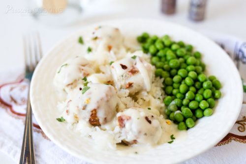 Pressure Cooker (Instant Pot) Chicken Parmesan Meatballs on a plate with a side of peas.