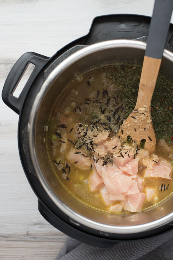 Overhead of Instant Pot cooking diced chicken in chicken stock and spices 