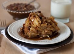 Pressure Cooker (Instant Pot) Cinnamon Raisin Bread Pudding with Caramel Pecan Sauce on a white plate