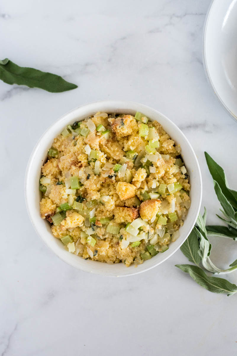 Overhead picture of cornbread dressing in a white ramekin, mixed and ready to be cooked in an Instant Pot.