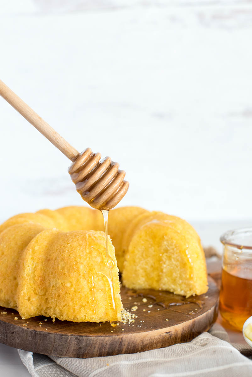 drizzling honey over a loaf of cornbread