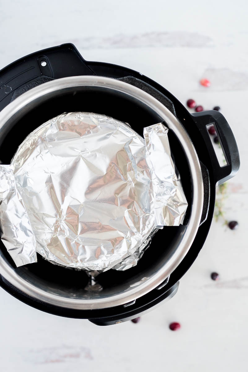 overhead of a springform pan wrapped in tin foil in an instant pot