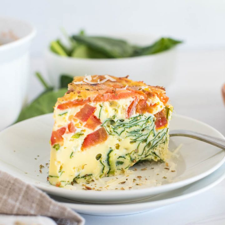 Close up of Instant Pot crustless spinach quiche topped with sliced tomatoes