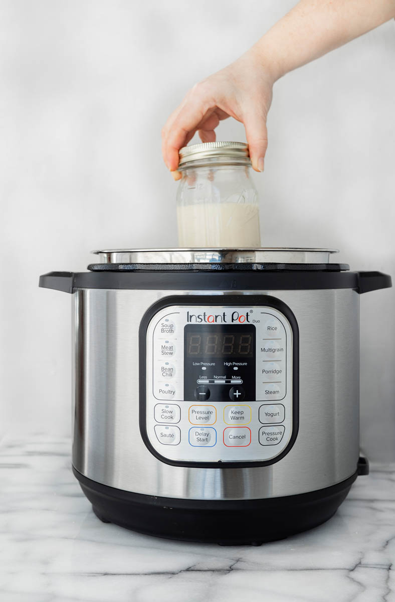 Adding the mason jar with sweet and condensed milk to an Instant Pot to make dulce de leche