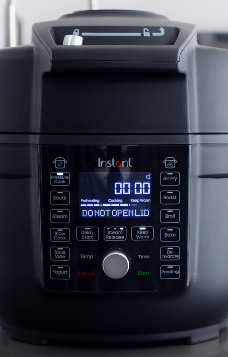 A close up of the Instant Pot Duo Crisp with Ultimate Lid display featuring the "Do not open" instructions while under pressure.