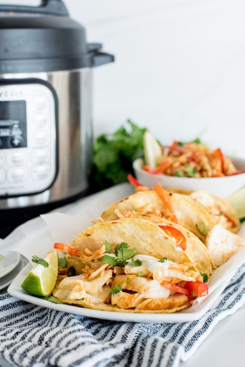 a thin white platter of cod fish tacos with cabbage coleslaw