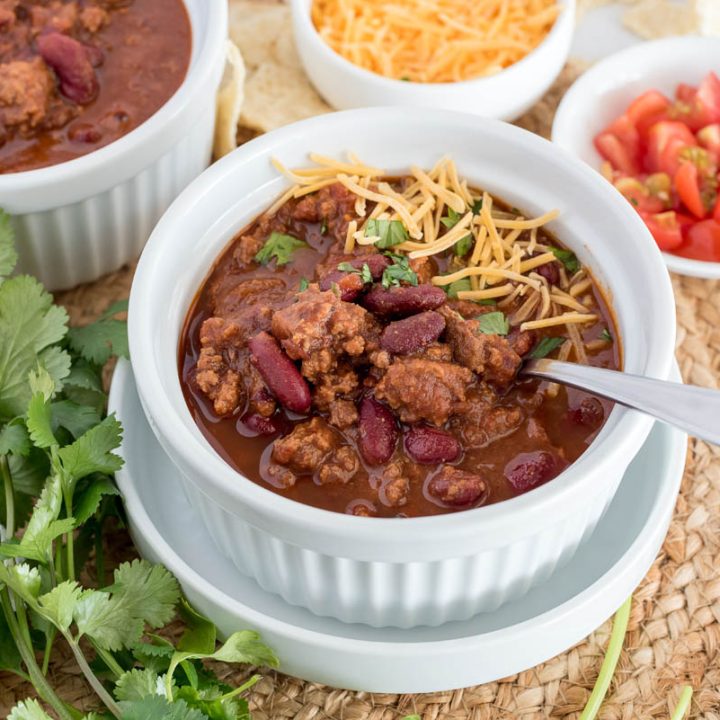 A 45 degree shot of Instant Pot Frozen Ground Beef Chili topped with shredded cheese and cilantro