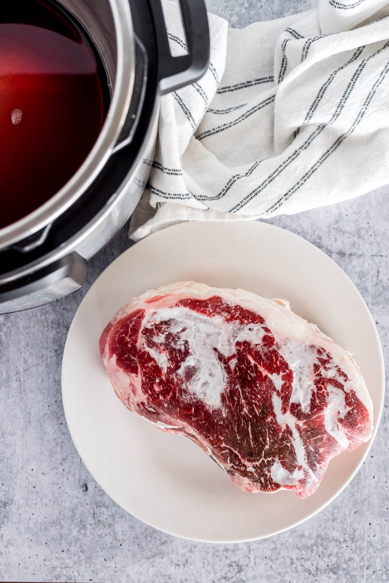 frozen beef next to an instant pot