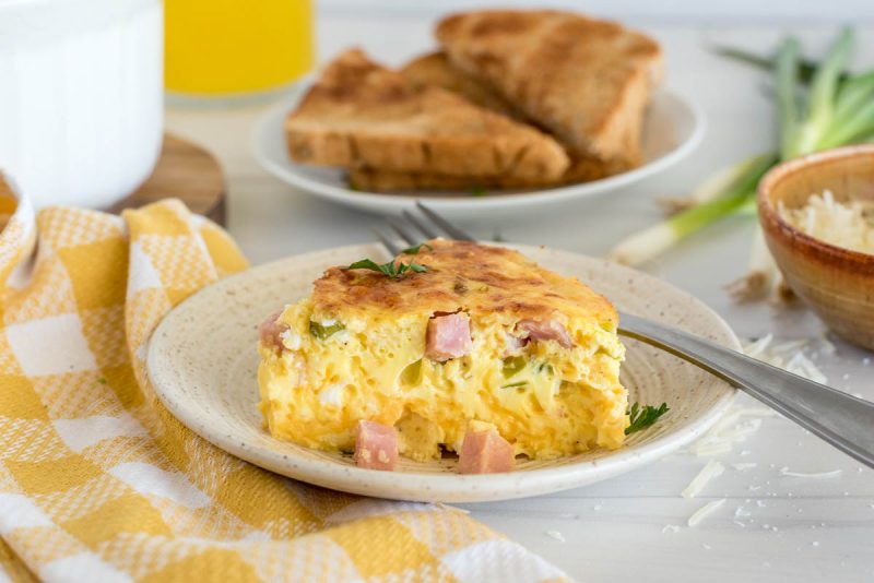 a side shot to show the texture of the ham and egg quiche, with a glass of milk and toast