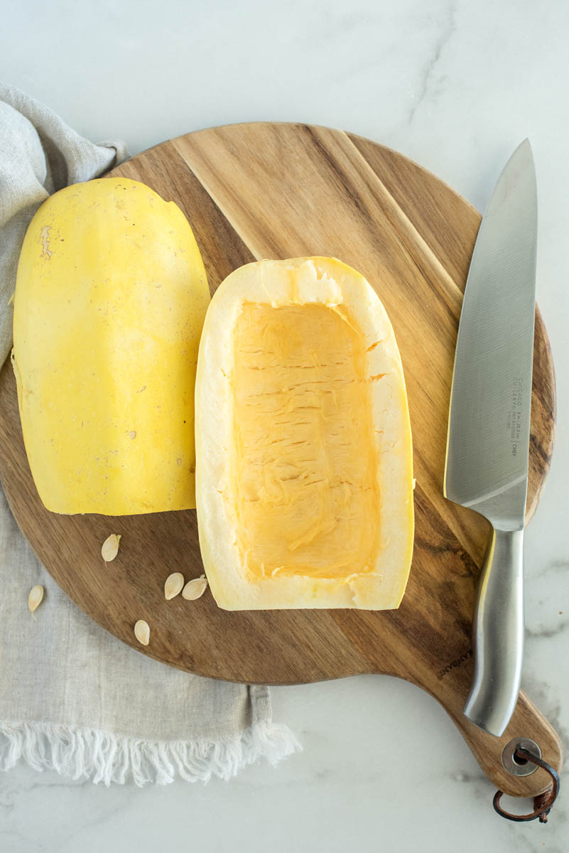 an overhead shot showing the spaghetti squash sliced in half lengthwise, with the seeds cleaned out and removed