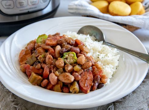 A bowl of Cajun 15 Bean Soup with sausage served over white rice