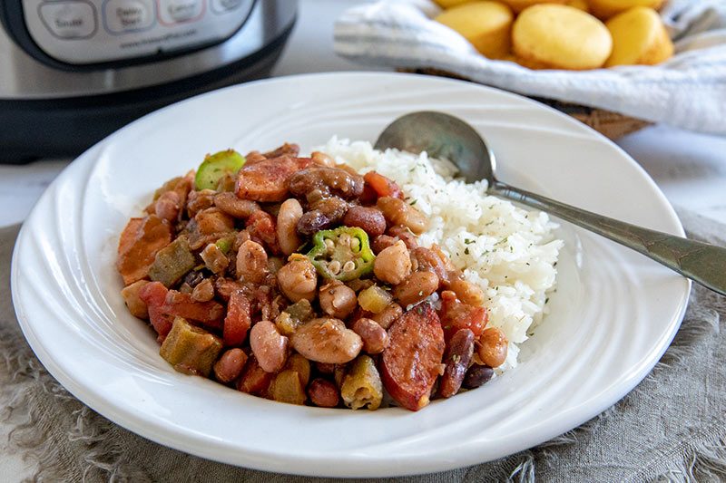 A bowl of Cajun 15 Bean Soup with sausage served over white rice