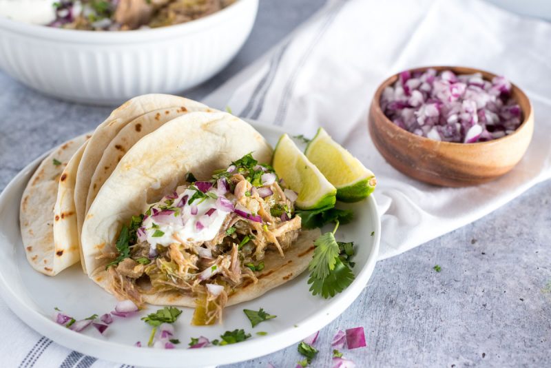 instant pot chili verde in tortillas with lime and chopped red onion