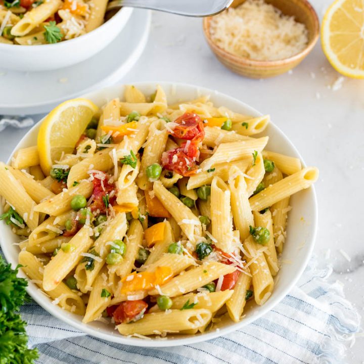 bowl of instant pot pasta primavera with fresh vegetables and parmesan cheese on top