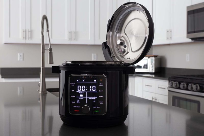 Instant Pot Pro Plus with a digital touch screen display on a kitchen counter with the lid open.