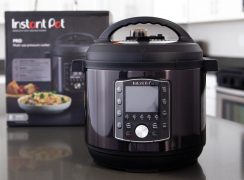 An Instant Pot Pro in black stainless steel sitting in front of the black Instant Pot box it came in