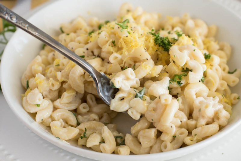 a close-up photo of a fork ready to take a bite of creamy lemon pasta