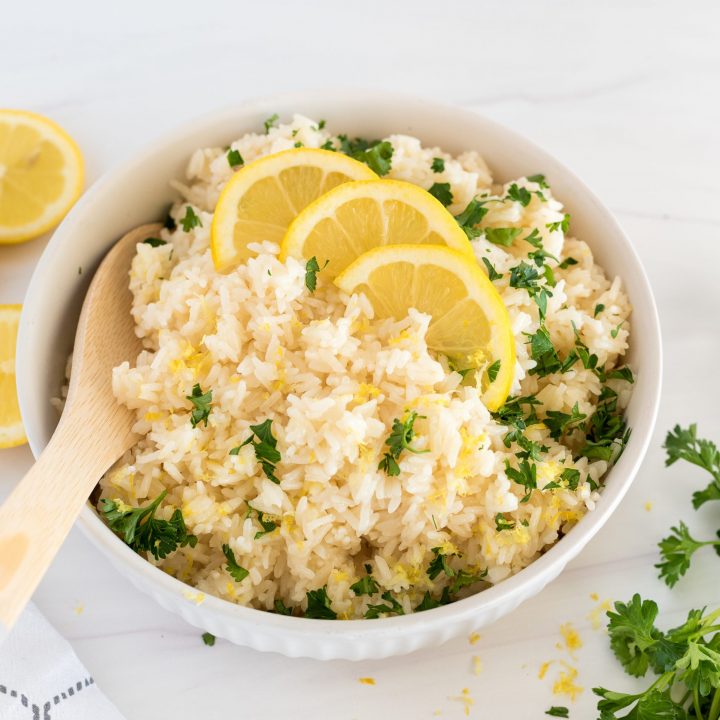 white bowl of instant pot lemon rice with a wooden spoon