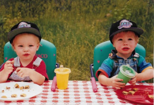  little boys sitting at a picnic table outside