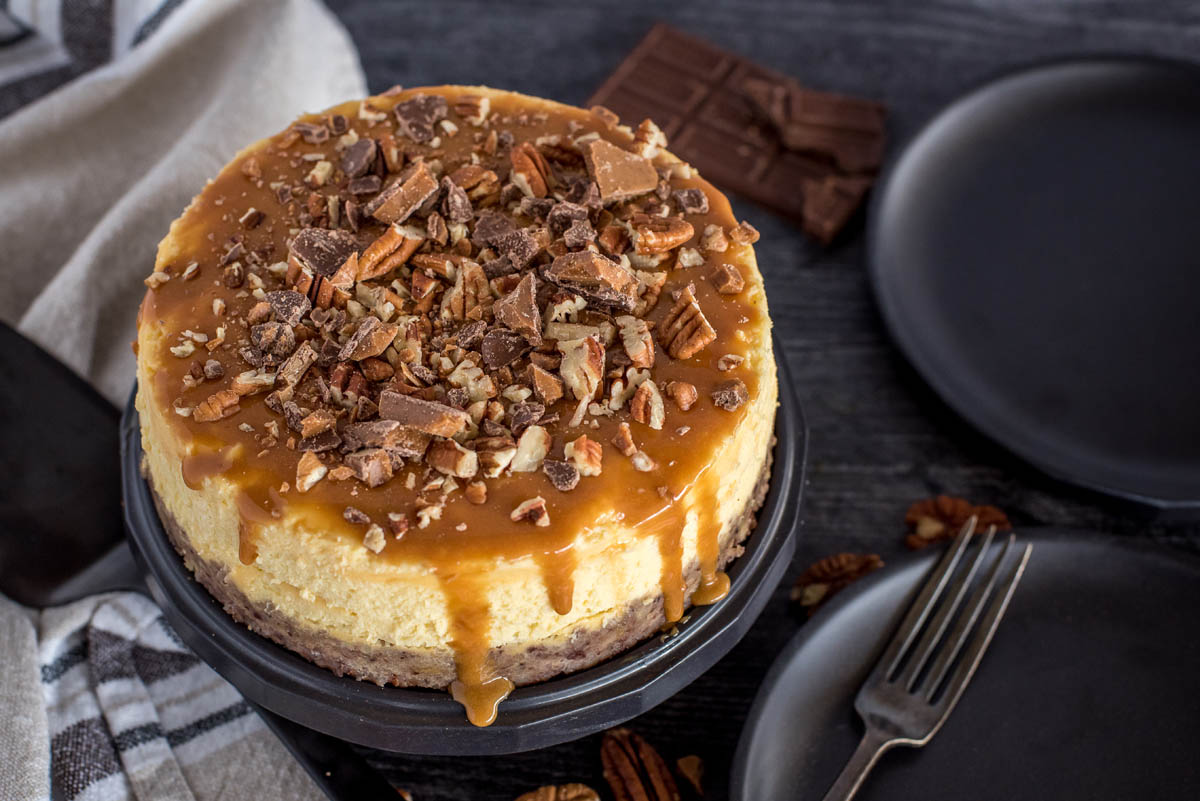 Overhead shot of an Instant Pot New York cheesecake topped with caramel, toffee, and pecans.