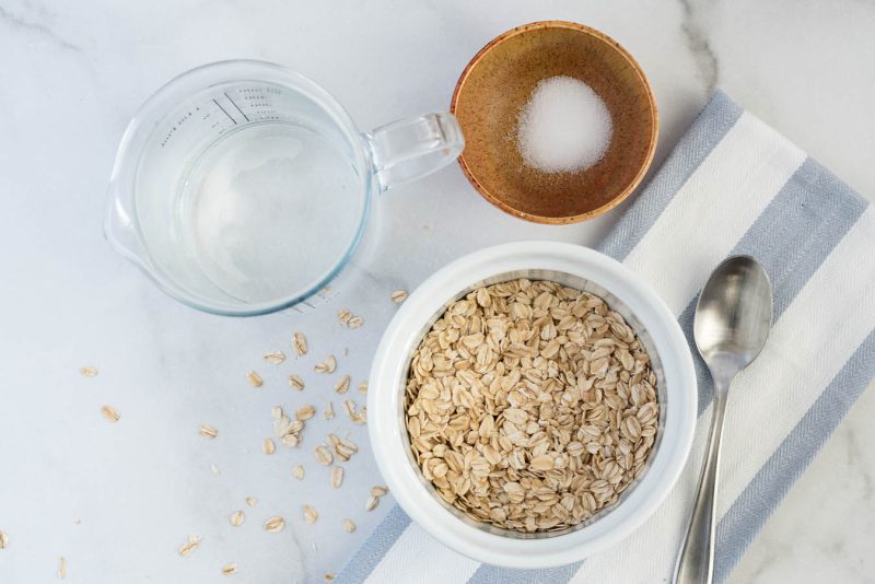 Overhead picture of ingredients for Instant Pot oatmeal for one, including rolled oats, water, and salt.