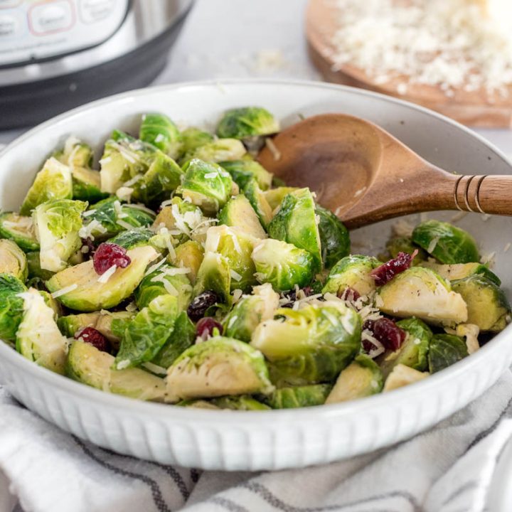 a close-up 45 degree shot of brussels sprouts being dished up by a wooden spoon