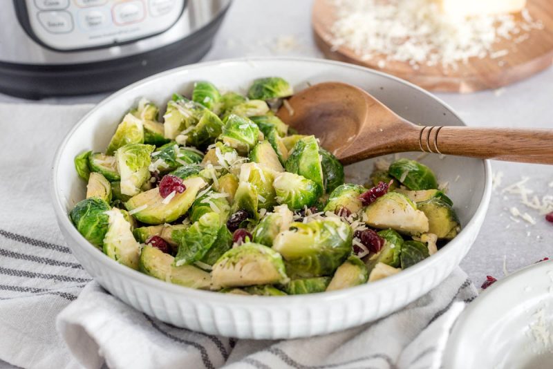 a close-up 45 degree shot of brussels sprouts being dished up by a wooden spoon