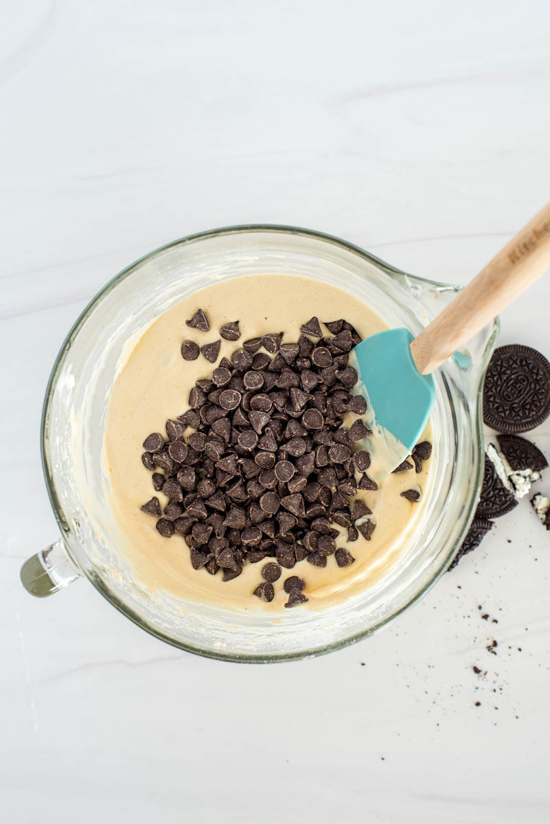 mixing peanut butter cups into batter for cheesecake