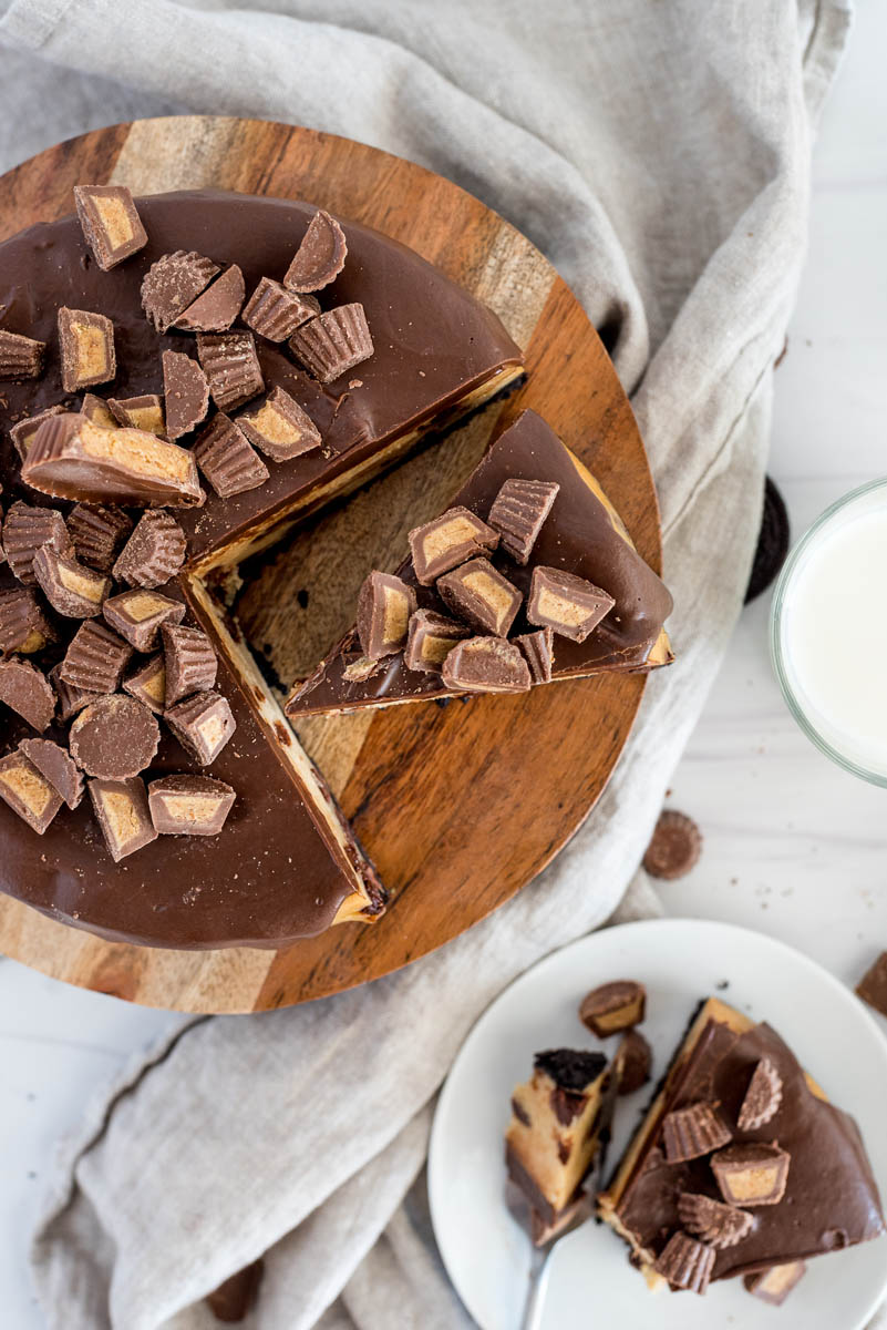 overheaad of a sliced peanut butter cup cheesecake on a cake stand