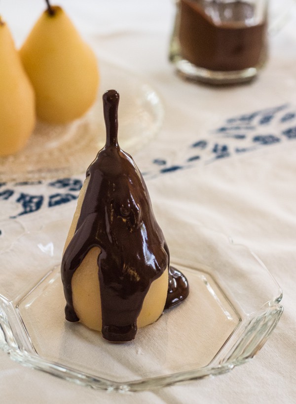 dessert plate with cinnamon poached pears dripping with chocolate sauce