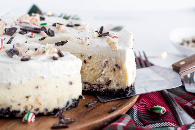 a close-up shot of a spatula removing a slice of peppermint cheesecake from the main cheesecake,