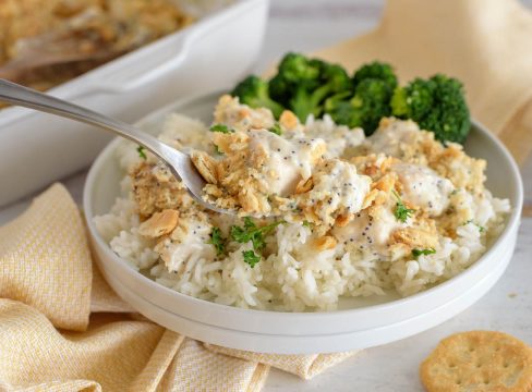 a side shot of a spoonful of poppyseed chicken casserole made in the Instant Pot served with steamed broccoli