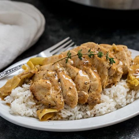 Pressure Cooker (Instant Pot) Artichoke Chicken over rice on a white plate with fork