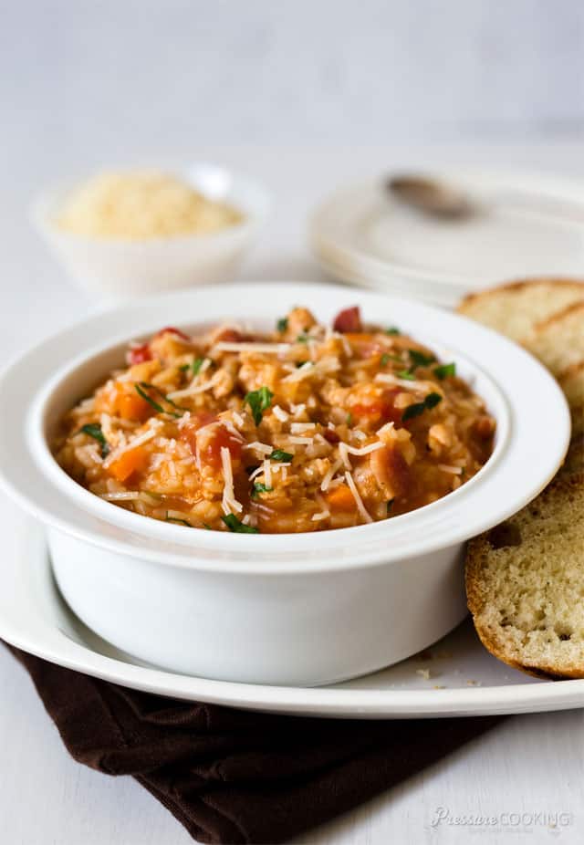 Risotto Bolognese in a white bowl with bread on the side