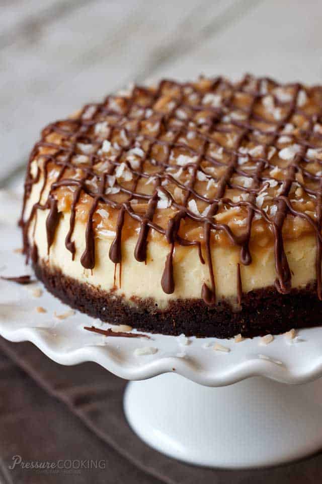 Pressure Cooker Samoa Cheesecake on a white cake stand