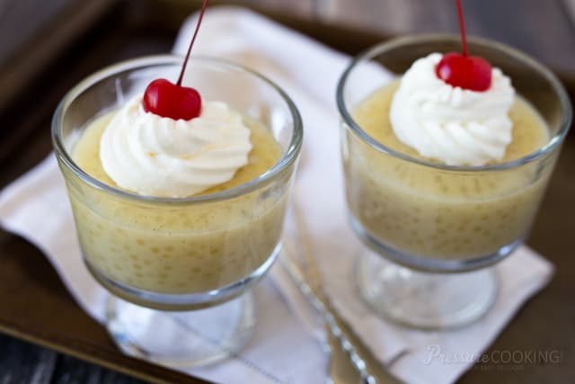 two dessert cups of Pressure Cooker (Instant Pot) Tapioca Pudding topped with whipped cream and a cherry