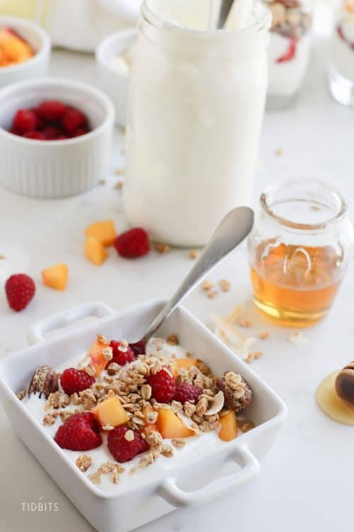 A close up of a plate of food on a table, with Granola and Yogurt